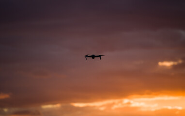 drone quadcopter with digital camera at beautiful sunrise sky.