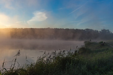 Fog on the pond in the morning dawn in the summer