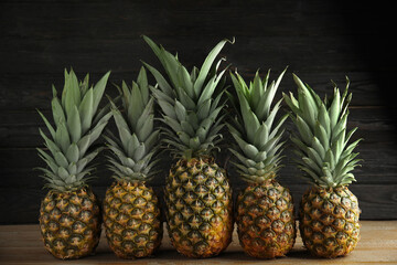 Fresh ripe juicy pineapples on wooden table