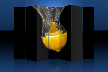 A lemon thrown into water makes a water column. Photo processed into an image with reflection.