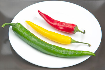 yellow, red and green hot chili on a plate. Pepper. Vegetable vitamin food.