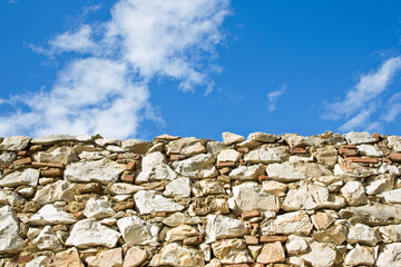 Stone wall with large stone blocks against a sky background