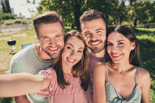Photo of company four fellows smiling recording video camera outside outdoors garden park forest
