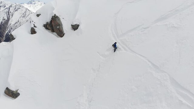4K person in full winter mountaineering equipment descending from snowy slope with hiking poles in hand. Environment concept