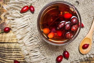 Rose hips tea on a rustic background