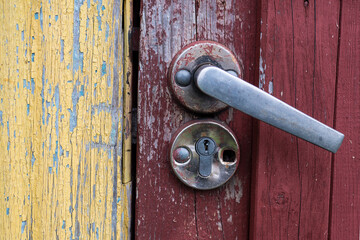 Old door handle on the red rusty door.