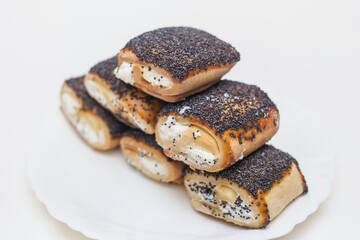 butter cookies with filling and poppy seeds on a white plate on a white background