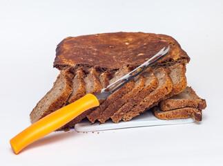 Rye homemade bread with a kitchen knife on a white background