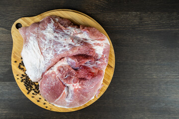 Juicy piece of raw meat on a round wooden Board. The view from the top.