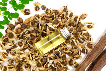Oil of Moringa in bottle, green leaves, pods and seeds isolated on white background. Moringa oleifera tropical herb product concept. 