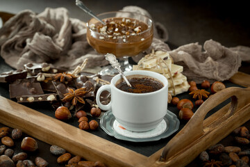 Hot chocolate on an old background in a composition with cocoa beans and nuts.