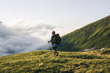 Obraz premium Traveling Man tourist with backpack hiking in mountains
