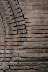 Brick wall and brick arch intersection. Dark brown brick texture.