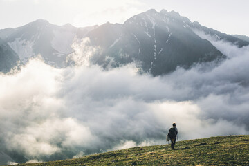 Woman hiking at sunset mountains with heavy backpack Travel