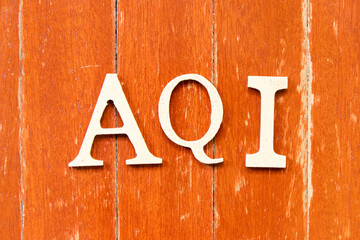 Alphabet letter in word AQI (Abbreviation of air quality index) on old red color wood plate...