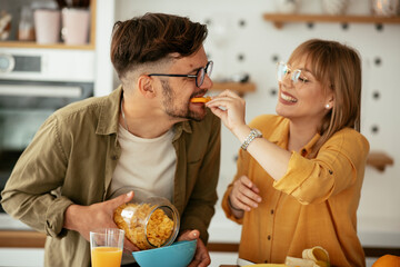 Young couple eating breakfast at home. Loving couple enjoying in the kitchen