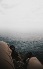 Fototapeta premium Traveler sitting on the edge of a cliff
