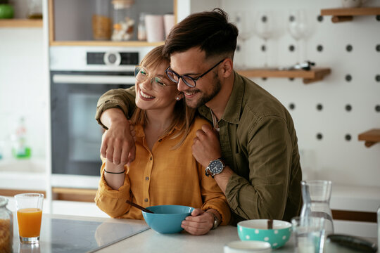 Young Couple Eating Breakfast At Home. Loving Couple Enjoying In The Kitchen