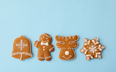 Different Christmas gingerbread cookies on light blue background, flat lay. Space for text