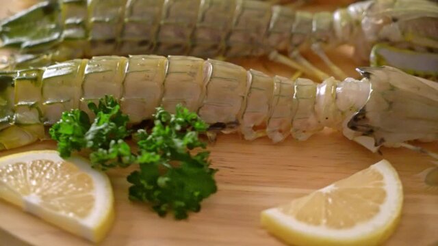 fresh mantis shrimp with lemon on wood board