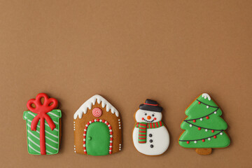 Different Christmas gingerbread cookies on brown background, flat lay. Space for text