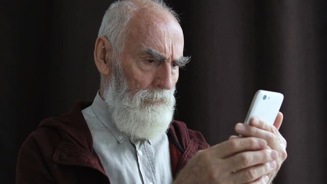 Upset mature male reading negative news in smartphone, bad information, failure