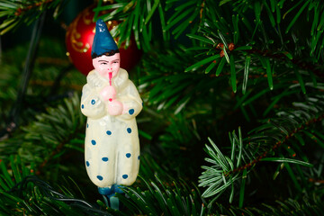 Old vintage glass toy, Pierrot on Christmas tree. Merry xmas and Happy New Year closeup background