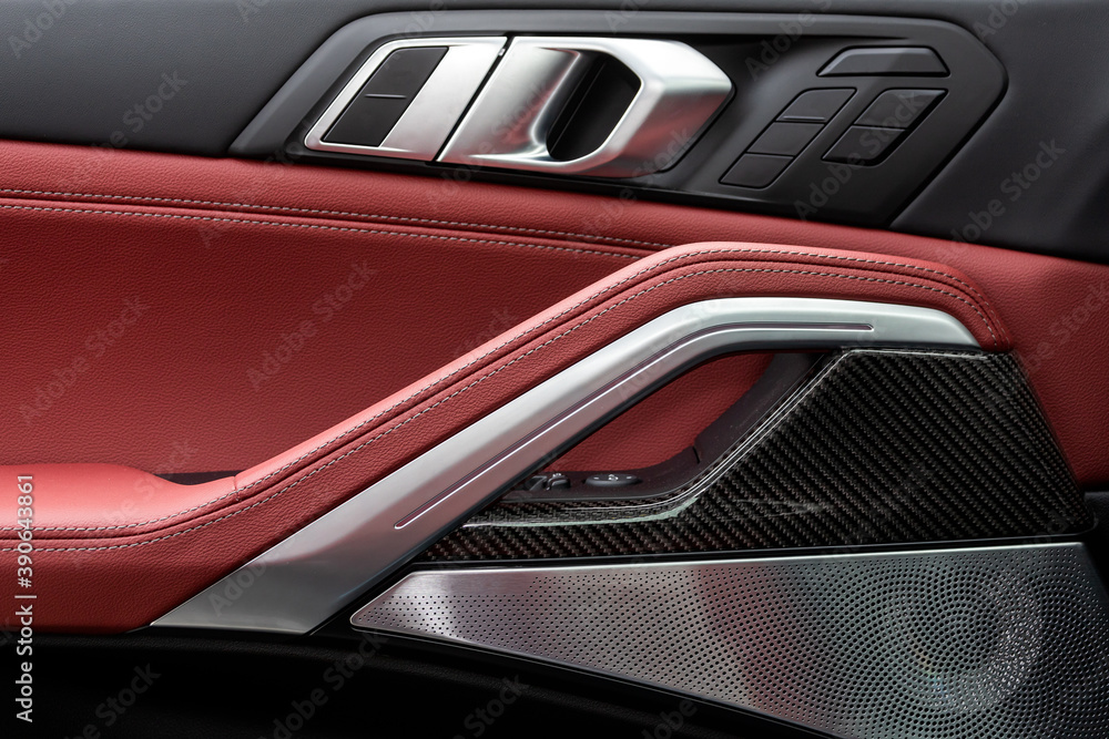 Poster сlose up of a door control panel with chrome handle on the car door, common black and red genuine le