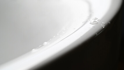 White ceramic bathtub with water drops
