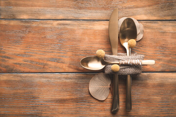 Set of cutlery and autumnal decor on wooden background, flat lay with space for text. Table setting...