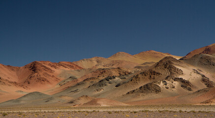 The Andes mountain range. Panorama view of the beautiful brown mountains high in the cordillera, under a deep blue sky in San Francisco Pass, Catamarca, Argentina. 