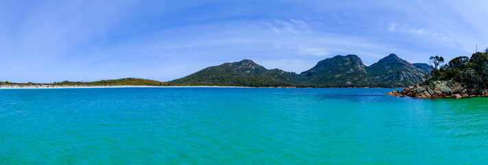 View of the coast of the Freycinet Peninsula, Tasmania from a boat on a sunny day
