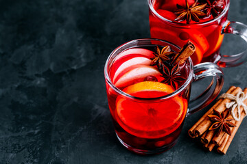 Christmas Mulled Wine with spices and fruits on a dark background, copy space.