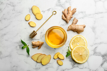 Ginger and other natural cold remedies on white marble table, flat lay