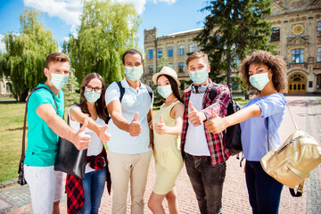 Photo portrait of six people showing thumb up wearing face masks near university