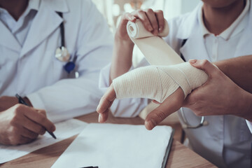 Doctor gently rewinds the man hand. 