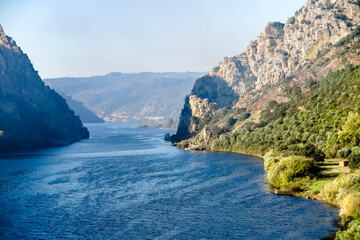 Tejo River crossing rocky cliffs of two mountains, Portas do Rodao, and vast vegetation, town Vila...