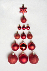 The Christmas tree is made from Christmas toys. Red balls and a star. Вackground from artificial...