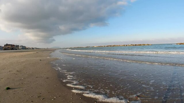 Timelapse in riva al mare onde nuvole e persone in 4K