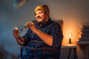 Chico joven alternativo con tatuajes delante de escritorio