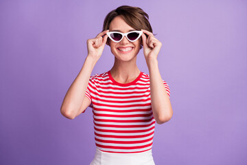 Photo of charming young lady look camera cheerful toothy smile wear sunglass striped t-shirt isolated violet color background