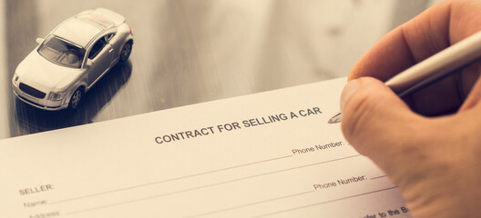 Hand writing a contract form for selling a car. Vintage style. 
