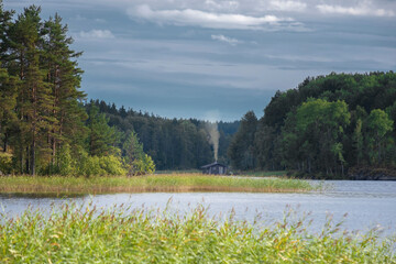 small hut by the lake in the northern forest in summer