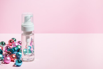 Mockup with transparent bottle of liquid cosmetic product oil or cleaning lotion with winter new year decorations