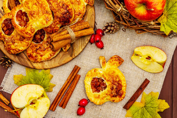 Homemade apple dessert, portioned puffs with fragrant cinnamon sticks, colorful foliage, autumn good mood
