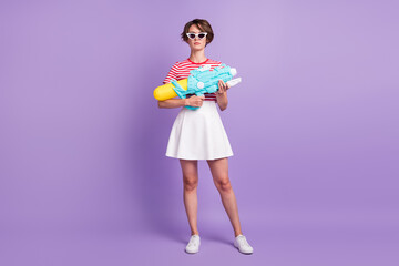 Obraz na płótnie Canvas Full length photo of girl hold pump pistol cool look camera wear striped t-shirt sunglass skirt footwear isolated violet color background