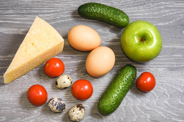 Fresh vegetables, fruits cheese and eggs on wooden background, top view. Ingredients for ketogenic diet, healthy food.