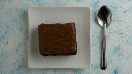 brownie with strawberry on plate on textured background