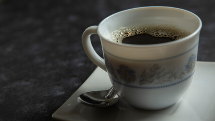 cup of coffee accompanied by plate on textured background