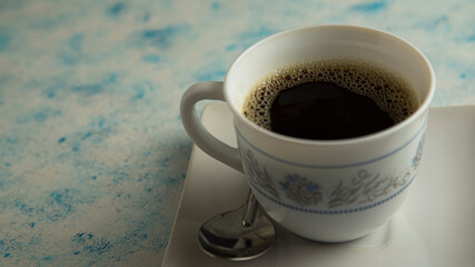 cup of coffee accompanied by plate on textured background